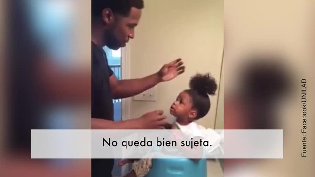 Este padre intenta domar el pelo rebelde de su hija