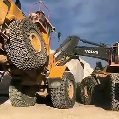 Powerful excavator trying hard to move a stone in mine. Almost falling.
