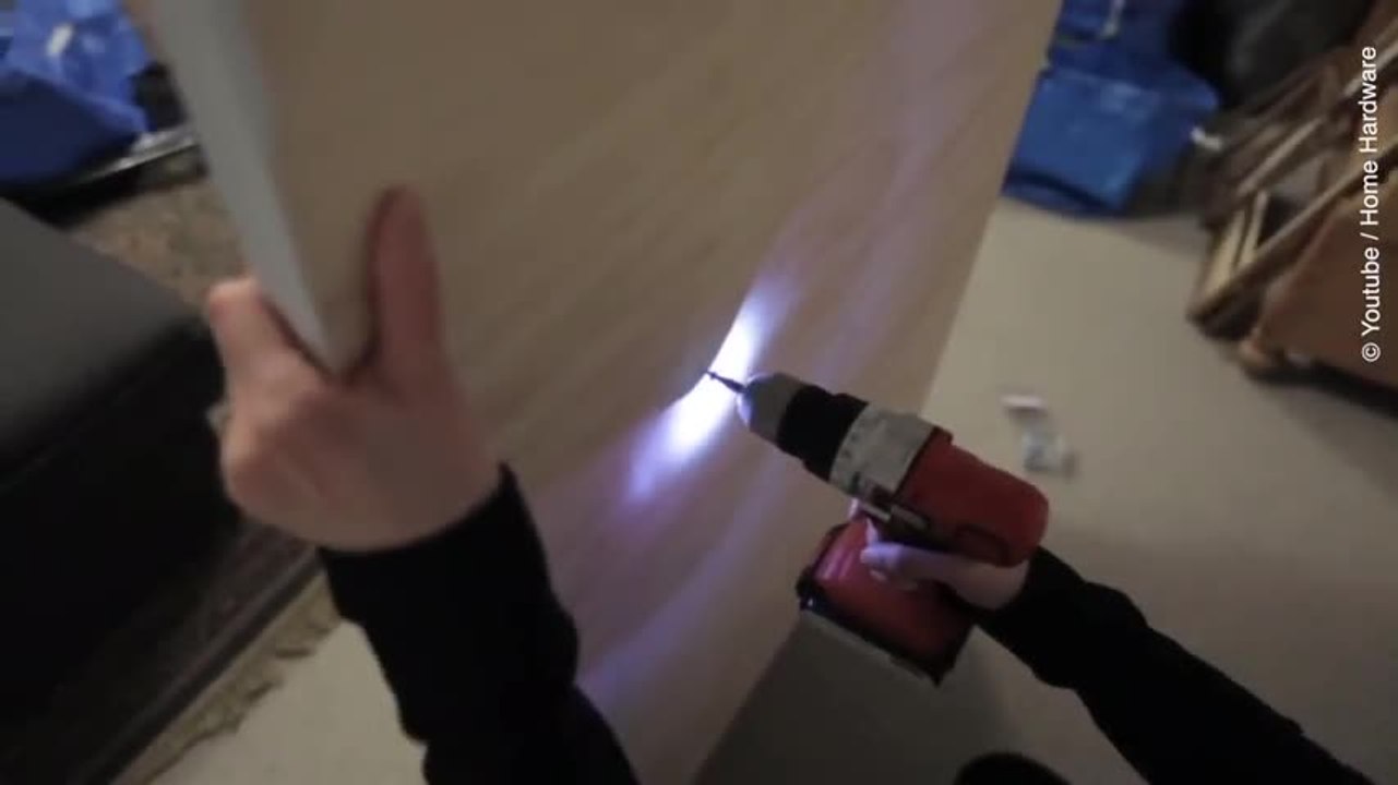 Elle creuse des trous dans une planche et l'accroche au mur. Regardez