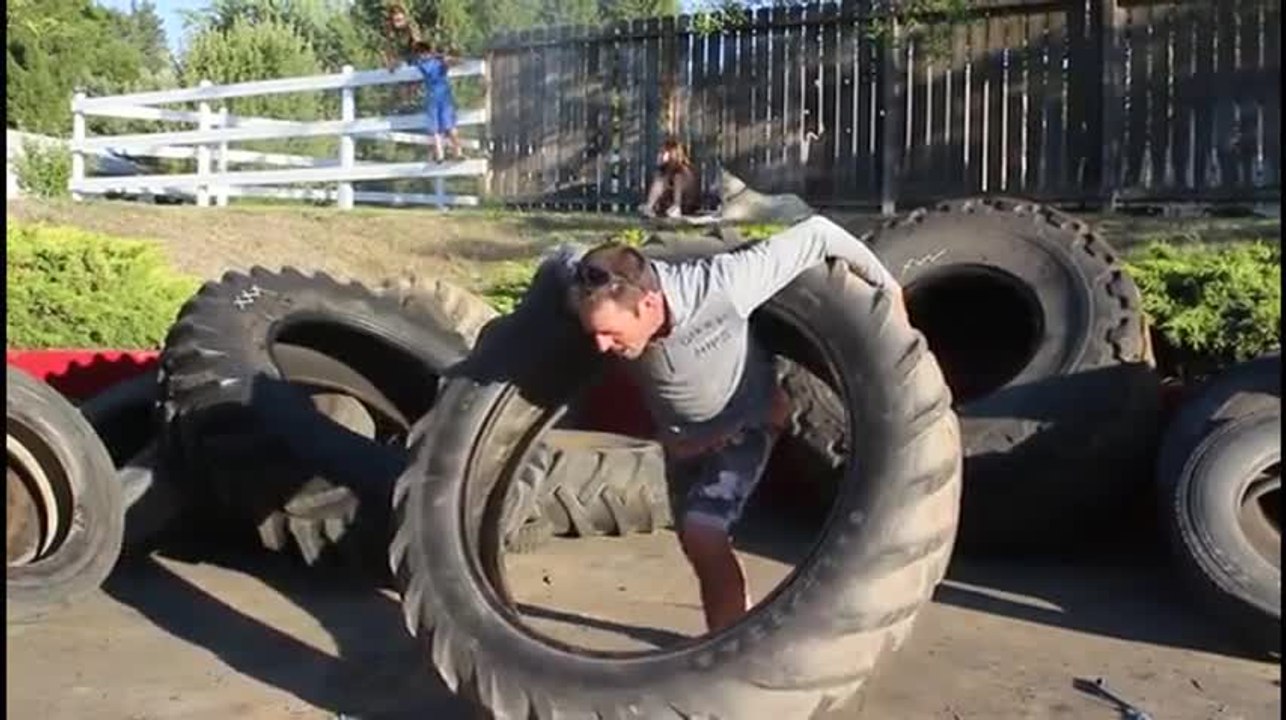 Il fait du hula-hoop avec une roue de tracteur