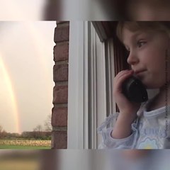 Une fillette téléphone à son amie en voyant un arc-en-ciel