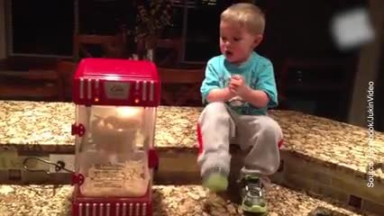 Un enfant est content de manger du pop-corn