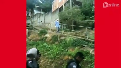 Policiais ajudam idoso a carregar sacos de areia