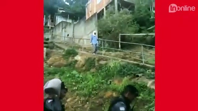 Policiais ajudam idoso a carregar sacos de areia