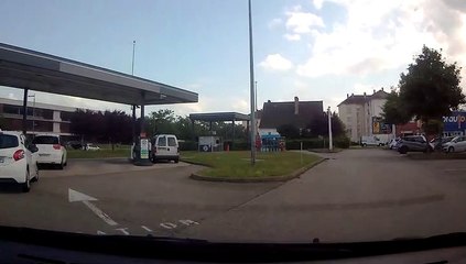 Femme au telephone à la pompe d'essence