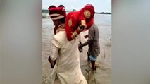 Flood: Groom carries bride on shoulders to cross river