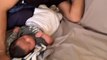 Baby Lies Awake in Bed While Dad Dozes Off While Taking Care of Him