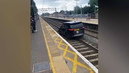 Commuters watch in horror as stolen Range Rover drivers down rail tracks at busy station