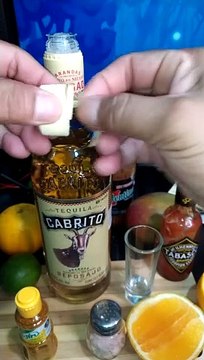 Destapando una botella de tequila cabrito reposado para un shot con sal de gusano de maguey