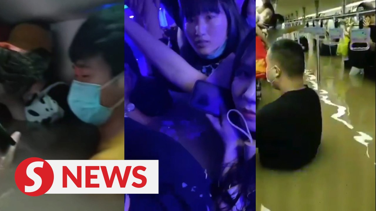 Subway passengers trapped waist-high in floodwaters as Chinese river banks burst