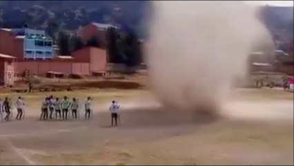 Un torbellino de polvo sorprende a unos futbolistas bolivianos en mitad de un partido
