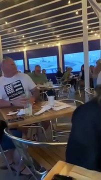 Ce petit garçon fait rire toute la salle de ce restaurant en levant les bras