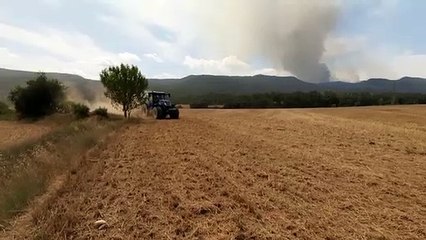 Els pagesos llauren els camps per fer de tallafoc en el cas que l'incendi hi arribi