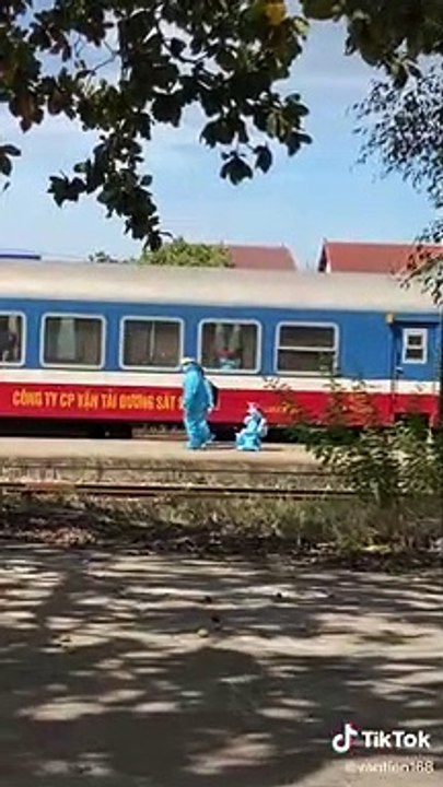 Hình ảnh cô gái nhỏ trong bộ đồ bảo hộ được chú cán bộ ân cần chăm sóc