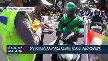 Polisi Sosialisasi Prokes Sambil Bagi Masker dan Bendera ke Pengendara Jalan