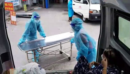 2 nữ tình nguyện viên bế F0 vào viên cấp cứu
