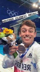 Télécharger la video: Tom Daley pose avec sa médaille au Tokyo Aquatics Centre, le 7 août 2021.