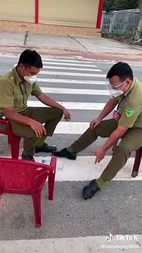 Hai cán bộ trực chốt chơi trò lộn chai nước và búng tai vui vẻ