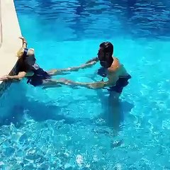 De férias, Lili Caneças faz exercício na piscina com ajuda de amigo