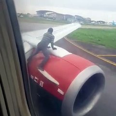 Homem sobe para asa de avião momentos antes da descolagem
