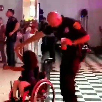 Polícia dança com menina cadeira de rodas