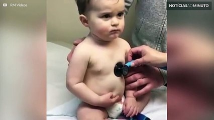 Bebé descansa na mão de enfermeira durante o exame