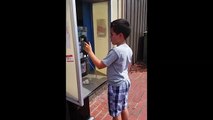 Criança confusa com cabine telefónica
