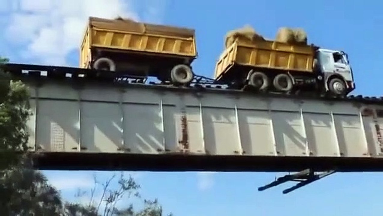 Au volant de son camion il traverse  un pont ferroviaire... en roulant sur les rails