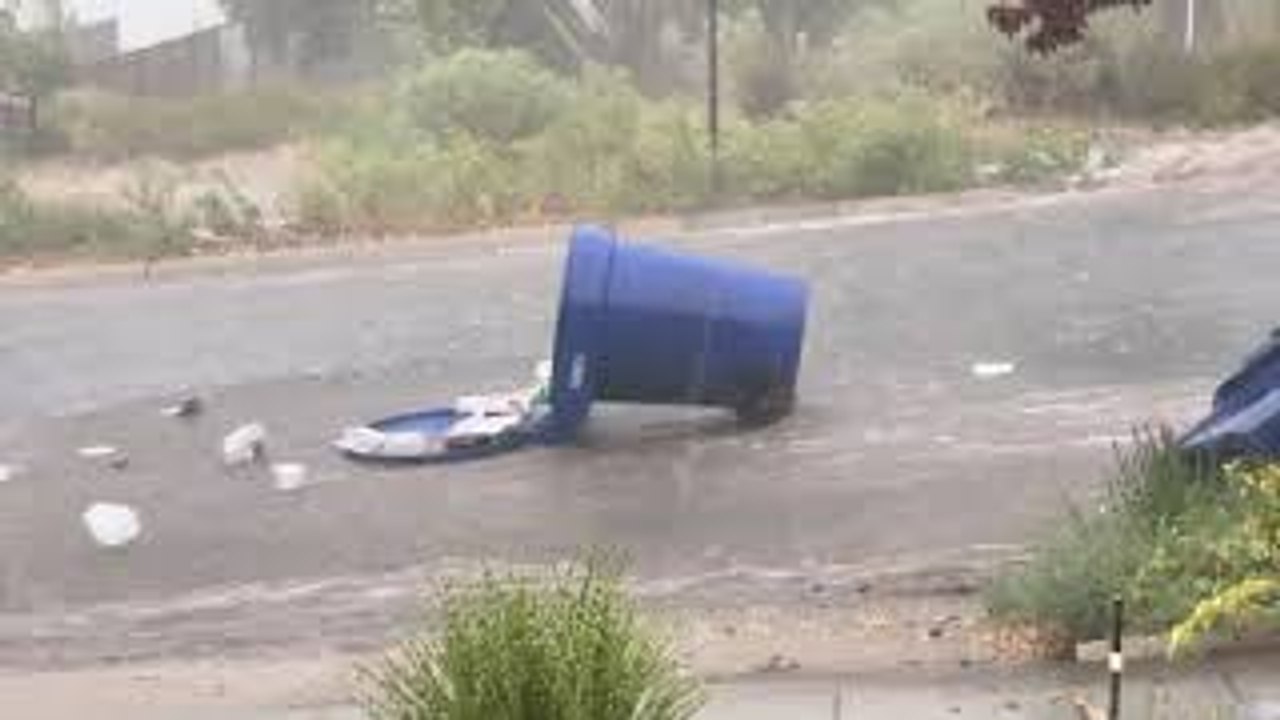 Garbage Cans Float Down Street During Flood