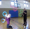 Duo of Jugglers Pass Rings to Each Other While Juggling Them