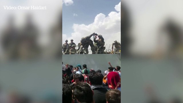 Afghan child passed over walls of Kabul airport amid chaotic scenes as many try to escape Taliban rule