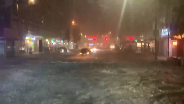 Passengers stand on seats as bus navigates flooded road