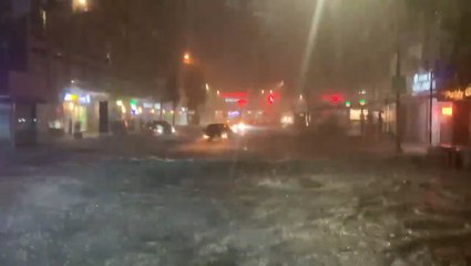 Passengers stand on seats as bus navigates flooded road