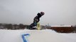 Snowboarder Practices Snowboarding While Jumping Over Springboard From Snow-Ramp