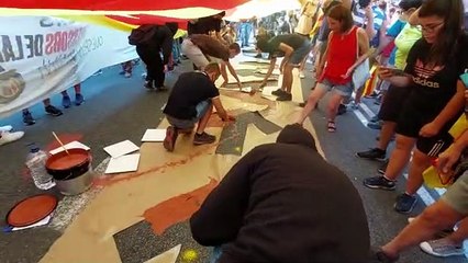 Un grup d'activistes pinta un mural al terra davant la comissaria de la policia espanyola a Via Laietana