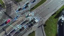 Top_Down_Aerial_Drone:_White_Autonomous_Self_Driving_Car_Moving_Through_City._Concept:_Artificial_Intelligence_Scans_Surrounding