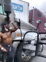 Guy Riding on Side of 18-Wheeler Holding Mirror