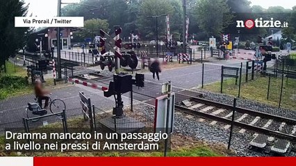 下载视频: Amsterdam, attraversa il passaggio a livello mentre arriva il treno: tragedia sfiorata