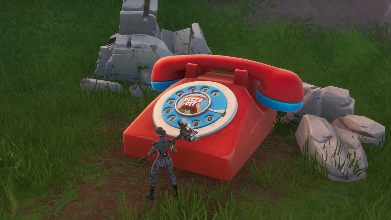 Fortnite : composer le numéro de Pizza Pit sur un téléphone géant au Bloc