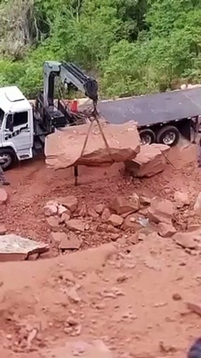 Régis charge un rocher sur un camion