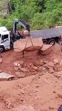 Régis charge un rocher sur un camion