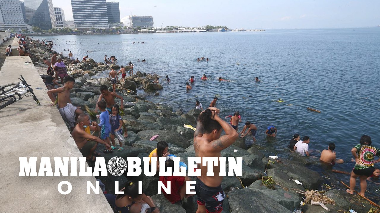 People plunge into the cool water of Manila Bay...