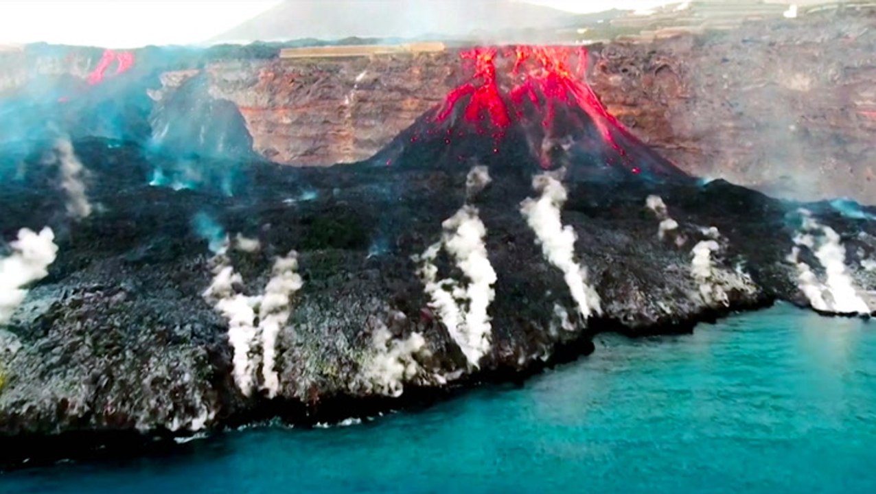 Spectacular videos show lava flowing into the o...