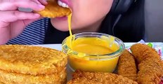 Eating crispy nugget with cheesy dipping sauce