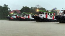 5 Tugboats pulling a huge barge during heavy rain in Thailand