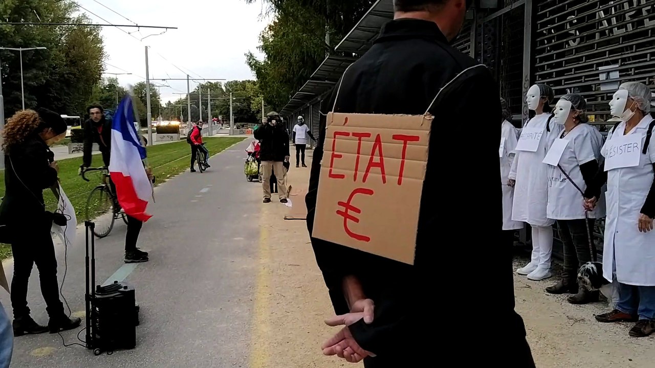 Derrière les grilles du stade des Alpes, les invités patientent et observent les manifestants