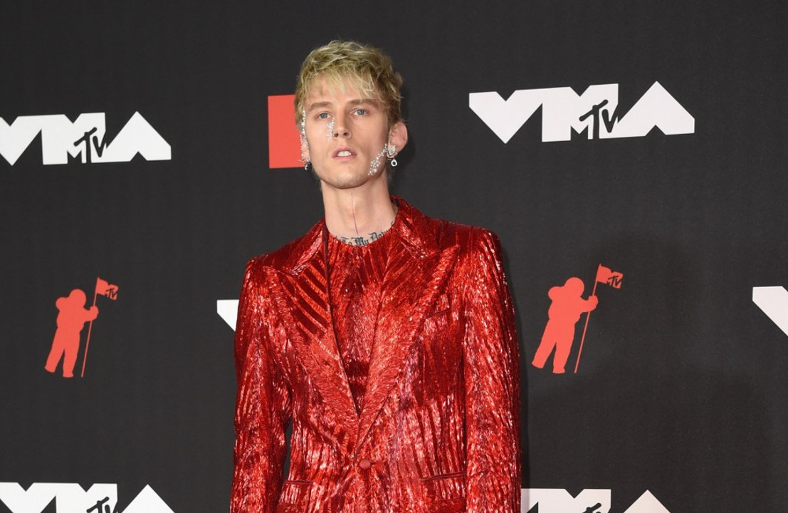 Machine Gun Kelly reçoit des bouteilles sur la...