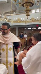 Un bébé fait pipi sur le prêtre pendant le baptême