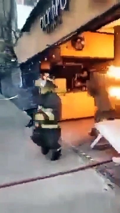 Un pompier sort avec une bonbonne de gaz en feu... Héros du jour