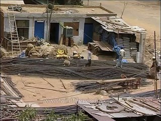 Workers cut iron rods with machine at Safdarjung Hospital